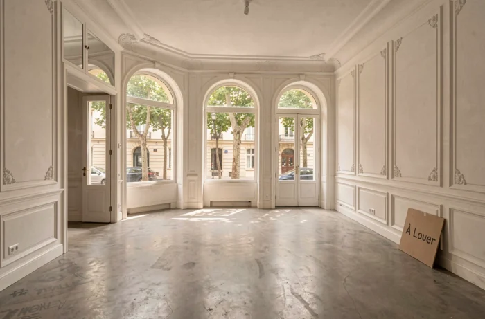 Empty office for rent in a renovated Haussmannian building in Aix-en-Provence with arched windows and a view of the plane trees